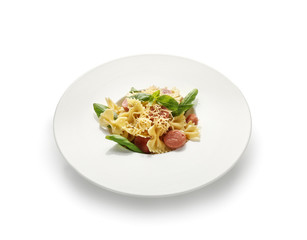 Plate with tasty macaroni and cut boiled sausages on white background