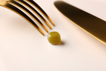 Eating of small peas on plate, closeup. Diet concept