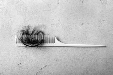 Comb with fallen down hair on grey background - obrazy, fototapety, plakaty