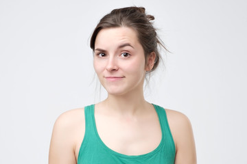 Fototapeta premium Doubting woman being disappointed or unimpressed over gray wall.
