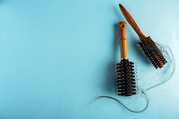Brushes with fallen down hair on color background