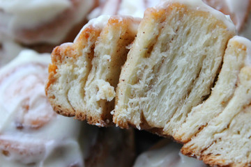 Beautiful fresh cinnamon rolls close-up on wooden grunge texture table. Fragrant homemade cakes, Cinnabon. A Cup of tea on a white saucer, cinnamon sticks. Delicious Breakfast buffet.