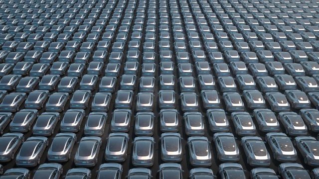 Electric cars waiting to be shipped aerial view of big parking lot depicting less demand during recession 3d rendering