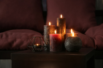 Beautiful burning candles on table in room