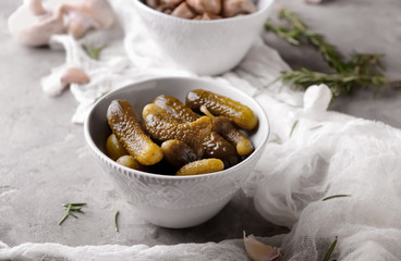 Bowl with tasty fermented cucumbers on grey table