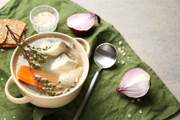 Pot of tasty hot soup on table