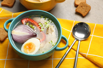 Pot of tasty hot soup on table