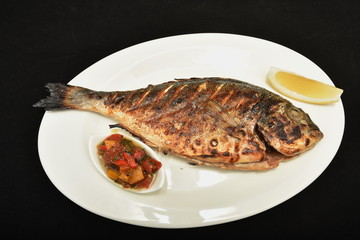  Roasted fish  dorada with lemon slices and  sauce