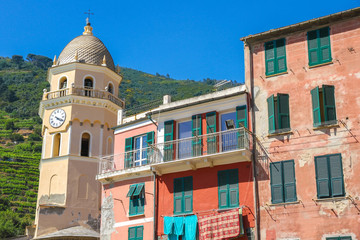 View over the the medieval clock tower of Cinque Terre, Italy with colourful houses on a sunny day.