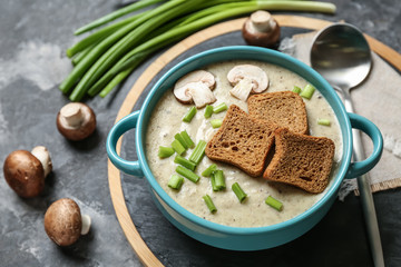 Pot of tasty hot soup on grey table