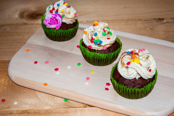 Muffins on a wood cutting board. cream decoration. tea. place for text.
