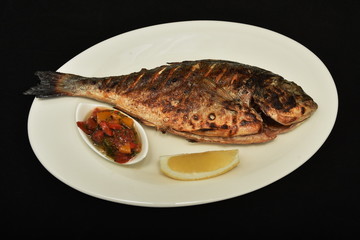  Roasted fish  dorada with lemon slices and  sauce