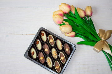 Chocolate candies in the box. Candy box and pink tulips