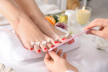 Young woman getting pedicure in beauty salon