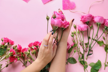 Fototapeta na wymiar Female hands with beautiful flowers on color background