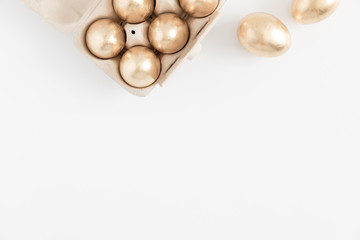 Easter golden eggs, easter decorations on white background. Flat lay, top view, copy space 