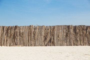Palm leaves fence in the sand