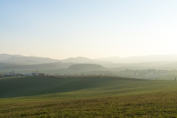Fototapeta na wymiar Misty morning on meadow with trees and views. Slovakia