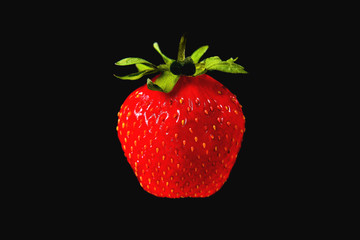 Strawberries on a black background with green leaves background close-up