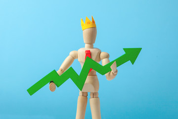 Businessman in tie and crown holding green arrow up on blue background. Good manager makes growth...
