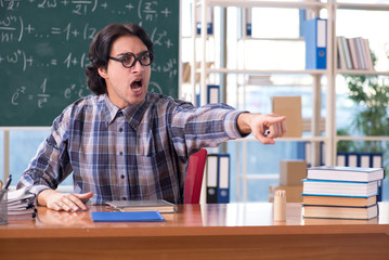 Young funny math teacher in front of chalkboard 