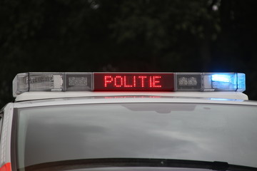 Police car in the netherlands with blue flash lights and text in roof console with STOP POLITIE...