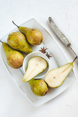 Fresh pears in a dish on a white background