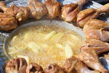 crispy chicken thighs  fried in oil and fried potatoes