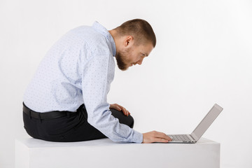 young handsome man in shirt and tie using laptop