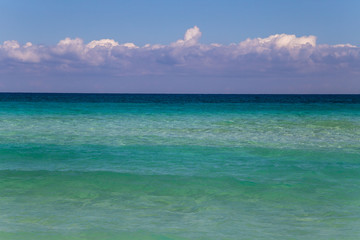 Fototapeta na wymiar Background of turquoise sea, sky and clouds
