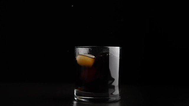 Adding ice in alcohol. Partly real time, partly slow motion. Shallow depth of field