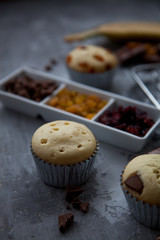 Freshly made vanilla muffins with dried fruit, raisins, cranberries and chocolate. As well as sliced banana. copy space