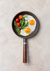 Fried eggs on pan at light background