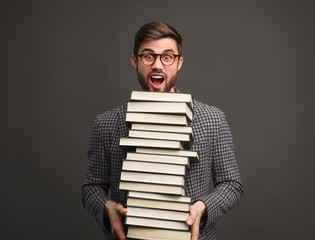 Student with stack of books screaming