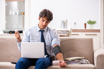 Man under stress measuring his blood pressure