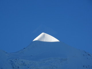Sonnenaufgang im Gebirge - Die Sonne kommt über den Berg und leuchtet die ersten Berggipfel an. Aufgenommen an der Jungfraujochbahn im Sommer.