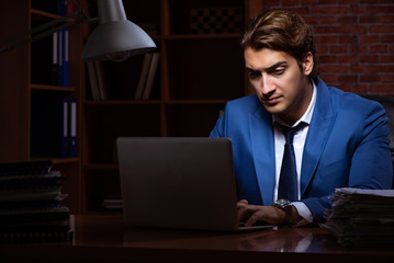 Young businessman working in the office at night 