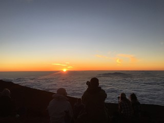 Fototapeta premium Sun setting on the clouds in Haleakala