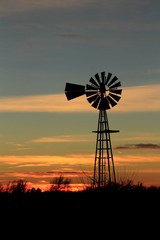 silhouette of windmill at sunset with clouds 
