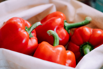 Reusable bag full of sweet peppers. Less plastic grocery concept. Closeup food photo of local market products 