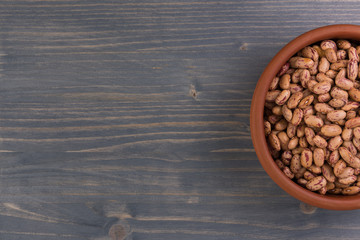 A plate of beans on wooden table background