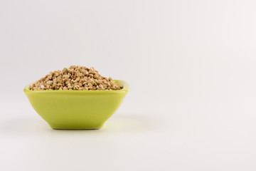Natural fresh green buckwheat in bowl isolated on white background.