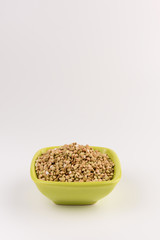 Natural fresh green buckwheat in bowl isolated on white background.
