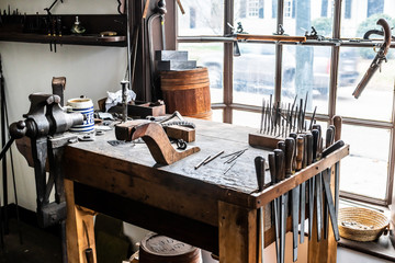 Vintage tools on a bench lit by a window, vice, gunsmith, gun, smith, blacksmith, classic, rusty, colonial era