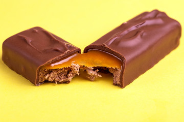 Separated on two pieces tasty chocolate bar with toffee