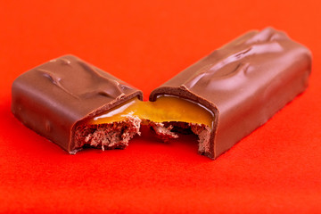 Separated on two pieces tasty chocolate bar with toffee