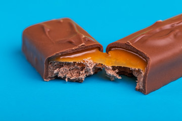 Separated on two pieces tasty chocolate bar with toffee