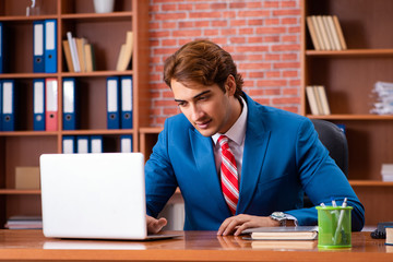 Young handsome employee sitting in the office  