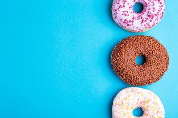 Obraz na płótnie Canvas Three tastes of donuts: berry, chocolate and vanilla