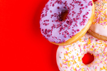 Delicious berry and vanilla donuts on bright red background